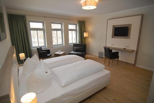 a hotel room with two beds and a living room at Hotel am Goethehaus in Weimar