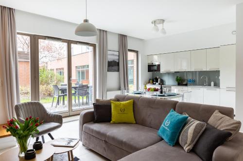 a living room with a couch and a kitchen at Apartamenty Gdańsk EU - Waterlane in Gdańsk