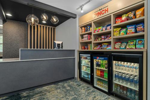 a grocery store with two refrigerators and shelves of food at TownePlace Suites Minneapolis West/St. Louis Park in Saint Louis Park