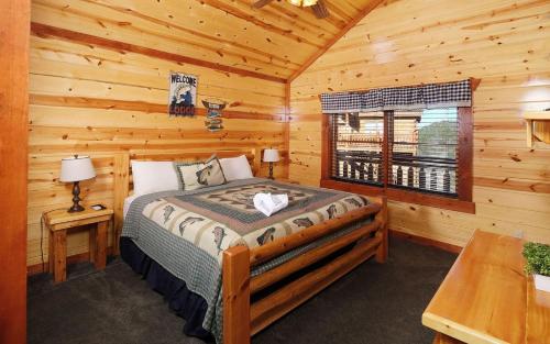 a bedroom with a bed in a log cabin at Splash N Mountain Lookout in Pigeon Forge