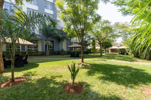 a park with palm trees and a building at Fairways Hotel Kisumu in Kisumu