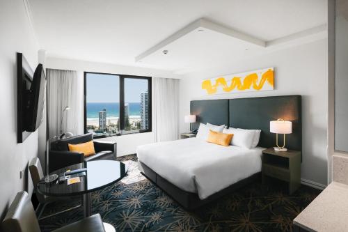 a hotel room with a bed and a large window at voco Gold Coast by IHG in Gold Coast