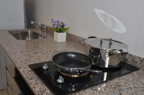 a stove with a pot on top of it in a kitchen at My Apart in Buenos Aires