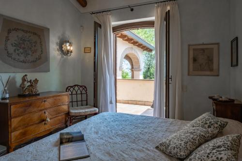 a bedroom with a bed and a dresser and a window at DOLCE COLLINA 10, Emma Villas in Cesena