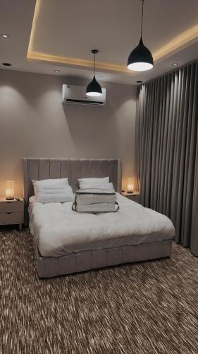 a bedroom with a large bed with two lamps at استديو - smart entry in Abha