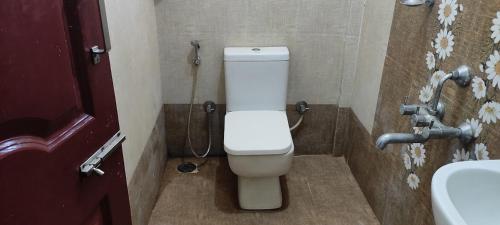 a bathroom with a toilet and a sink at ADH Raj Pride in Mysore