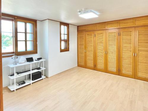 an empty room with wooden cabinets and a desk at Gangneung Sia Stay in Gangneung