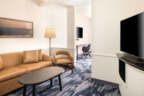 a living room with a couch and a flat screen tv at Fairfield Inn & Suites – Buffalo Airport in Cheektowaga