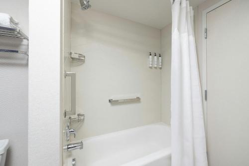 a bathroom with a shower with a white shower curtain at Fairfield Inn & Suites – Buffalo Airport in Cheektowaga