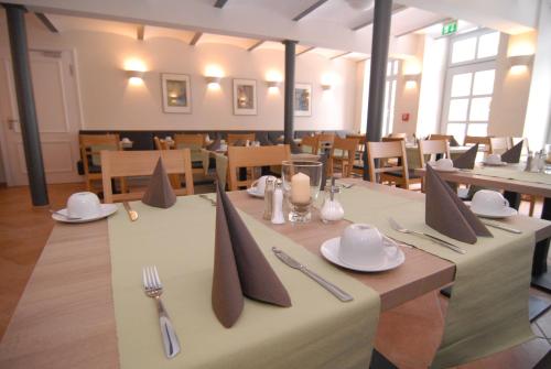 a dining room with tables with napkins and utensils at Hotel am Goethehaus in Weimar