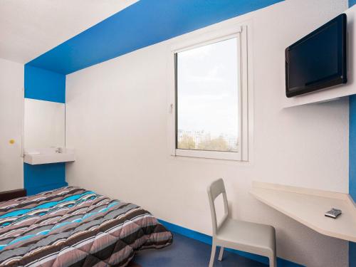 a room with a bed and a desk and a television at hotelF1 Merlebach Saarbrueck in Merlebach
