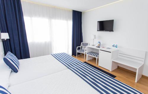 a hotel room with a bed and a desk at Hotel Voramar in Benidorm