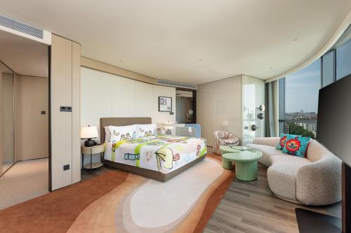 a bedroom with a bed and a chair and a couch at Holiday Inn Changchun High Tech Zone by IHG in Changchun