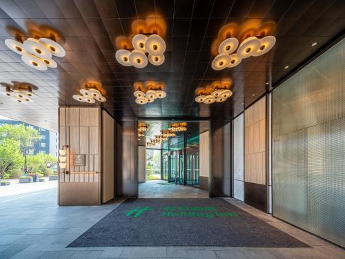 a hallway of an office building with chandeliers at Holiday Inn Changchun High Tech Zone by IHG in Changchun