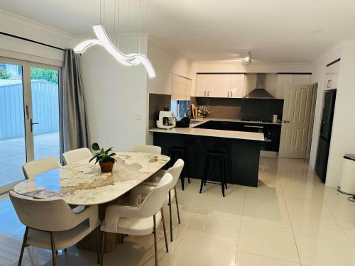 a kitchen and dining room with a table and chairs at Spacious Stay near Karrinyup in Perth