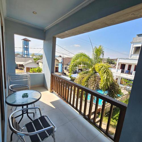 a balcony with a table and chairs and a view at Ridho Malik Hotel in Bumbang