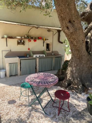a table and two chairs next to a tree at Casettina Matilda in Ostuni