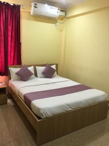a bedroom with a bed with a air conditioner on the wall at ADH Raj Pride in Mysore