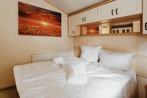a white bed with two towels on top of it at Villa Hexenholz in Thale