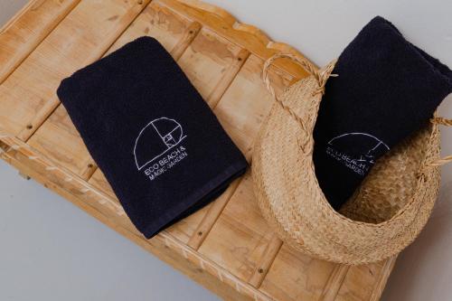 two black towels are sitting on a wooden tray at Eco Beach And Magic Garden Hotel in Gennadi
