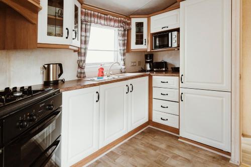 a kitchen with white cabinets and a stove at Villa Hexenholz in Thale