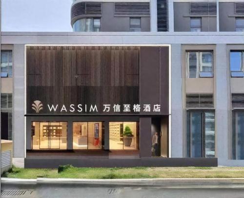 Un edificio con un cartel en el frente. en 济南中央广场万信至格酒店, en Jinan