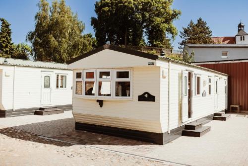 a white tiny house sitting in a parking lot at Villa Hexenholz in Thale