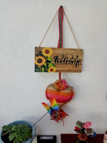 a sign that says welcoming hanging on a wall at Casa Villamor in Máncora