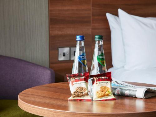 two bottles of soda and snacks on a table at Leonardo Hotel Dublin Christchurch in Dublin