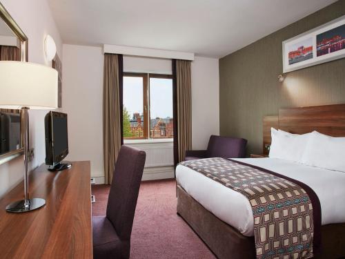 a hotel room with a bed and a television at Leonardo Hotel Dublin Christchurch in Dublin