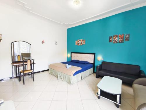 a bedroom with a bed and a couch at YUTAKA INN Global Juanda Sidoarjo in Kalangan