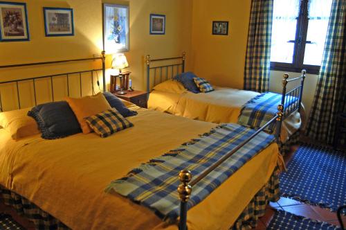 Duas camas num quarto com paredes amarelas em Villa de Fujacos em Valença