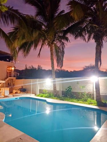 a swimming pool with a view of the ocean at night at Casa Villamor in Máncora