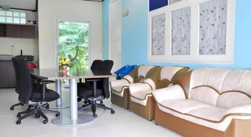 a waiting room with chairs and a table in a room at At Home Suanphung in Ratchaburi