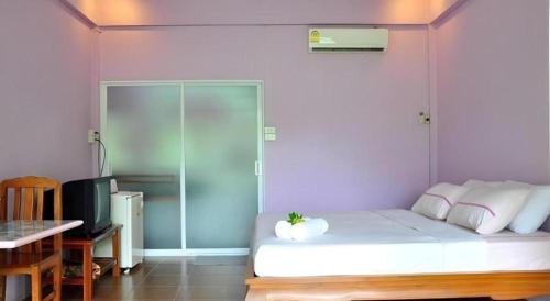 a bedroom with a white bed and a desk at At Home Suanphung in Ratchaburi