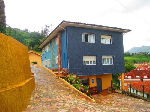 a blue building on top of a stone walkway at Hotel Brisas del Sella in Ribadesella