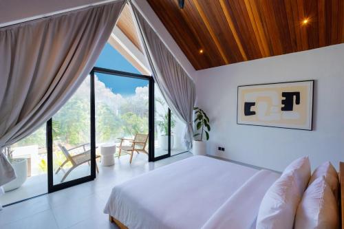 a bedroom with a bed and a large window at Villa Kanu in Uluwatu