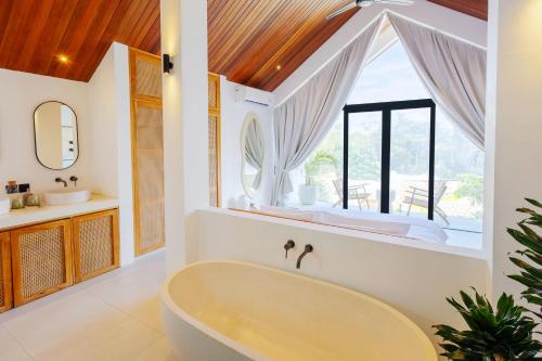 a bathroom with a tub and a window at Villa Kanu in Uluwatu