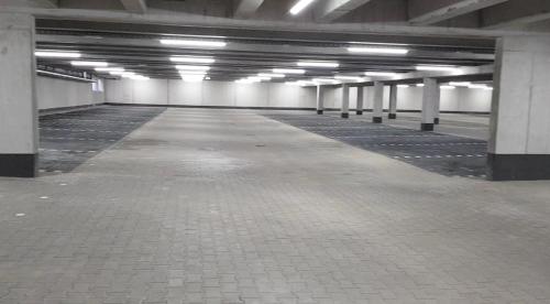 an empty parking garage with white columns and lights at McDreams Hotel Essen in Essen