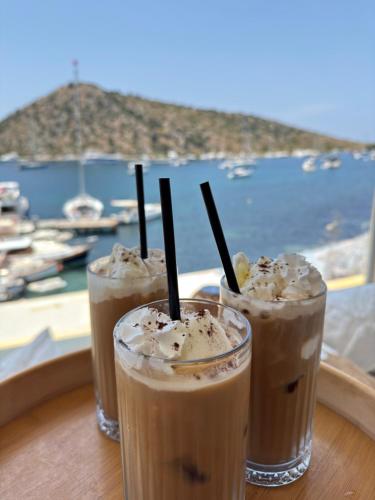 three drinks sitting on a table in front of a window at Liman Hotel Gümüslük - Adult Only in Bodrum City