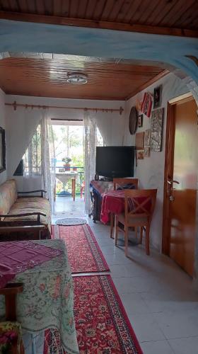a living room with a bed and a table at Private Room Near Palioura Epanomis in Epanomi