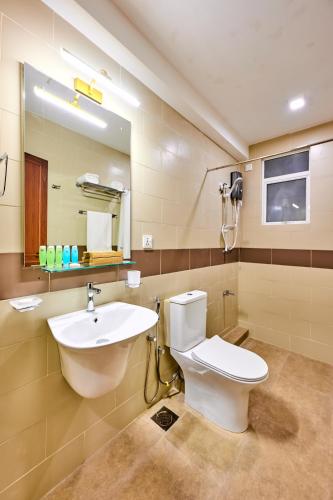 a bathroom with a sink and a toilet and a mirror at Dutch Heritage Colombo in Colombo