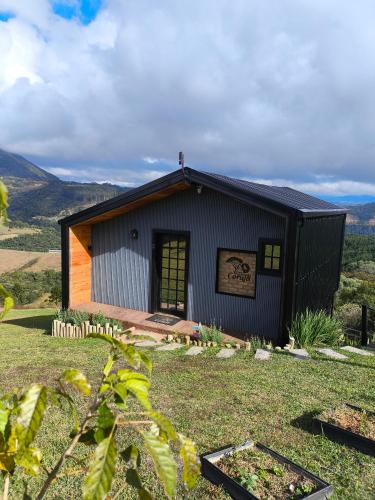 a small black building with a sign on it at Chalé Recanto da Coruja 2 in Barracão