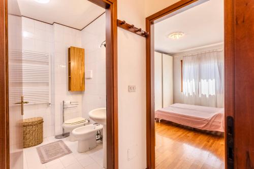 a bathroom with a toilet and a bed in a room at Via Moro - Home 86 in Quarto dʼAltino