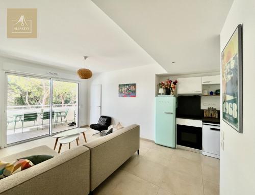 un salon avec un canapé et une cuisine dans l'établissement Le Coba Beach - P3 Cosy, Clim, Parking, Plage à 10 min à pied, à La Grande Motte