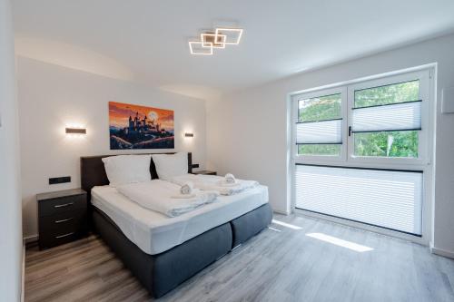 a bedroom with a large bed and two windows at BPS Apartment #11 Flair - NATUR - NEU - Deluxe - Modern in Horb am Neckar