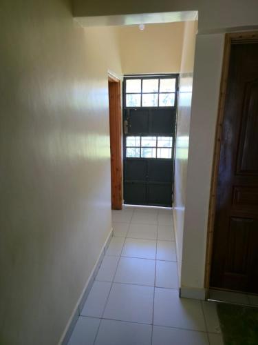an empty room with a door and a window at Nyodera Homes Furnished Apartments in Oyugis