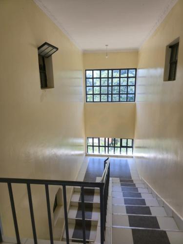 a room with a staircase and a window at Nyodera Homes Furnished Apartments in Oyugis