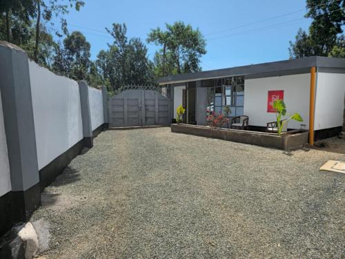 a home with a fence and a driveway at Nyodera Homes Furnished Apartments in Oyugis