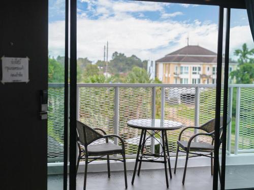 a balcony with a table and chairs and a view of a building at B2 Krabi Premier Hotel in Ao Nang Beach